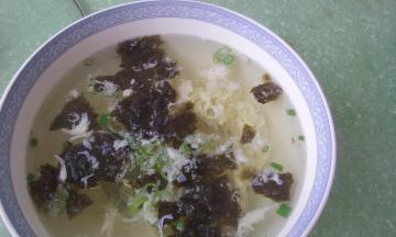 将热汤倒入盛有紫菜和葱花的碗中