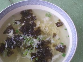 将热汤倒入盛有紫菜和葱花的碗中