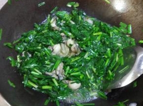 锅内热油放姜蒜,加入韭菜进行翻炒,加入海蛎子