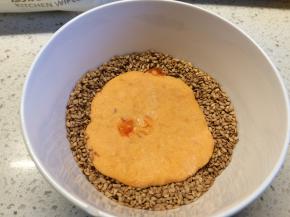 将小饼放入盛有芝麻的碗中，略按压，使其两面均匀粘上芝麻