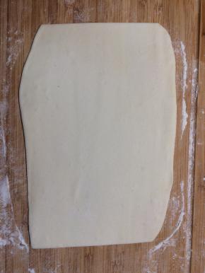 将醒好的面团取出，加适量干面粉揉至没有明显气泡，擀成厚度约1.5mm的长条形面片