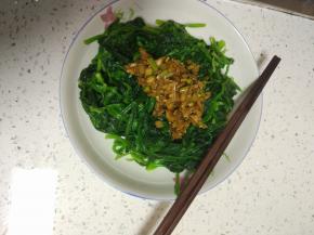 控干水分的菠菜放入盘内，加入调好的酱汁