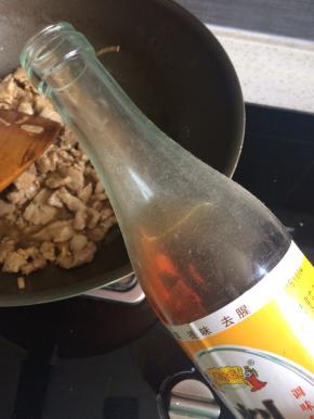 热锅凉油下一半葱姜蒜爆香，这里可根据个人喜好加入花椒和八角，下肉片，加料酒去腥