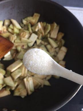 热锅凉油下剩下的葱姜蒜爆香，下茄子片，翻炒一分钟后加入适量食盐继续翻炒至茄子变色