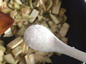 热锅凉油下剩下的葱姜蒜爆香，下茄子片，翻炒一分钟后加入适量食盐继续翻炒至茄子变色