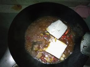 倒入适量的水、料酒、蒜、姜、豆腐，