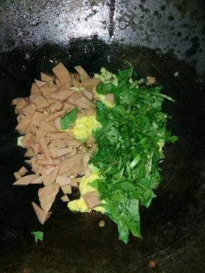 1分钟后，放入切好的香肠粒和青菜，翻炒