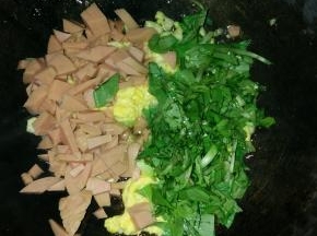 1分钟后，放入切好的香肠粒和青菜，翻炒
