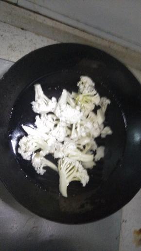 在锅内倒入适量的水烧开放入花菜，加入盐