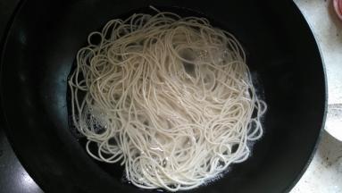 在锅内倒入适量的水，水烧开后放入面条