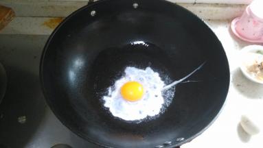 在锅内倒入食用油，打下一个鸡蛋，煎一个荷包蛋