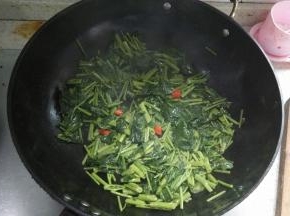 当空心菜炒至略为干瘪的时候，放入盐味精，翻炒一会出锅盛盘即可