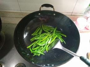 在锅内倒入适量的油，在油中倒入少许盐，然后放入辣椒翻炒