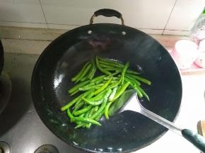 在锅内倒入适量的油，在油中倒入少许盐，然后放入辣椒翻炒