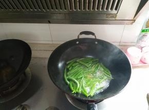 等到辣椒翻炒至有些干瘪后，再倒入少许水，盖上锅盖