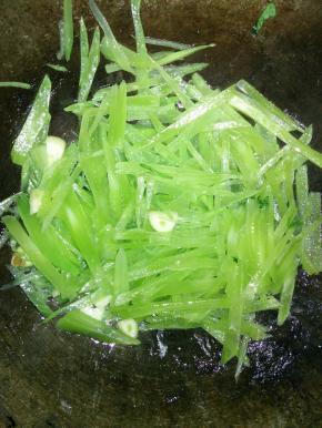 在锅内倒入适量的花生油，爆炒大蒜，放莴笋
