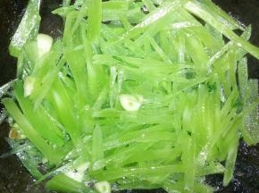 在锅内倒入适量的花生油，爆炒大蒜，放莴笋