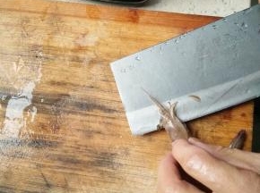 用菜刀将虾从中间剖开，从头一直到尾部，尾部不能全部剖开