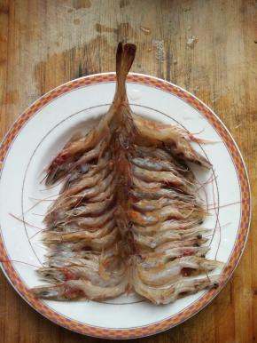 将剖开的虾，洗净后一个个摆在盘中