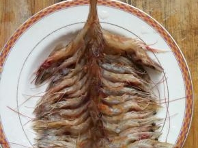 将剖开的虾，洗净后一个个摆在盘中
