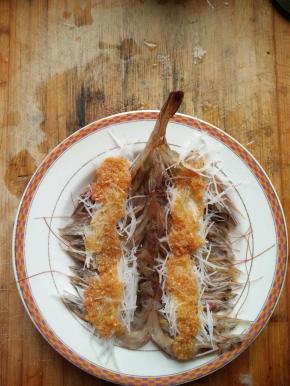 在虾上面均匀放上浸泡过的龙须米线和自己调制的蒜泥