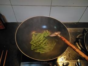在锅内倒入适量的花生油，放入洗净的四季豆，翻炒