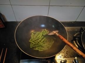 在锅内倒入适量的花生油，放入洗净的四季豆，翻炒