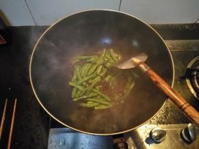 5分钟后在锅内倒入适量的笋干菜，并不断翻炒