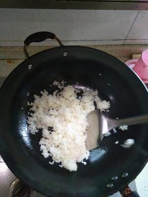 在锅内倒入适量的花生油，放入炒饭，翻炒