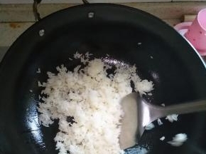 在锅内倒入适量的花生油，放入炒饭，翻炒