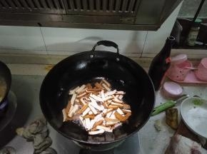 在锅内倒入适量的花生油，倒入豆腐干翻炒，