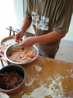 左手拿皮， 右手拿筷子放适量的豆腐馅、肉馅，喜欢豆腐馅的可以多放些豆腐；喜欢肉馅的可以多放些肉沫