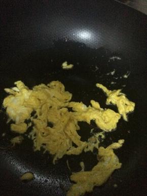 锅内加入适量油，把鸡蛋放入锅中翻炒成块状。盛出