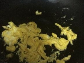 锅内加入适量油，把鸡蛋放入锅中翻炒成块状。盛出