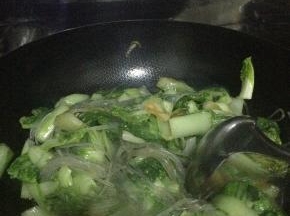 翻炒两分钟左右，锅内放入少量的水，把粉条放入锅内