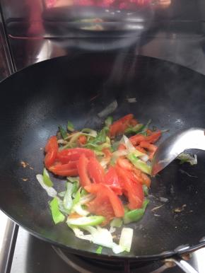 把葱放入锅中爆炒，随后放入西红柿炒一分钟左右。加入水