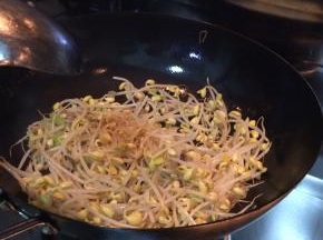 锅内放入适量食用油，盐，姜丝。把豆芽放入锅内翻炒。