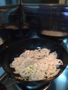 锅内放入葱大火爆炒，之后放入藕片转中小火翻炒。放入适量的盐和水，酱油。