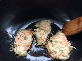 锅内均匀放入油。油到七成热，用炒勺成块状放入锅内。