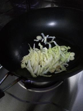 白菜切成段状。锅内加入适量油，放入葱和白菜爆炒。
