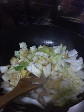 锅内加入适量油，放入白菜和土豆炖几分钟左右。土豆七成熟。加入适量的水。