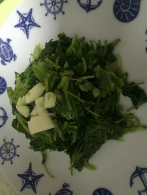 将大蒜拍开，切碎，置于香菜上