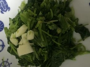 将大蒜拍开，切碎，置于香菜上