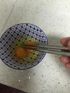 将鸡蛋打碎，在鸡蛋里加入料酒和盐搅匀