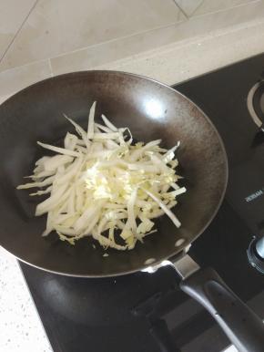 锅内放油烧热，加入适量的葱和大蒜爆香，加入白菜帮进行翻炒，炒出水分之后再加入白菜叶，炒软之后加入适量的水烧开