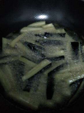 锅内加入适量油，烧开，把茄子。土豆，长豆角分别放入锅内炸至金黄捞出。