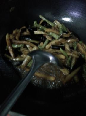 锅内放入少许油，放入葱，然后把炸好的土豆。茄子和长豆角放入锅内翻炒，加入调料。