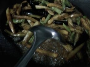 锅内放入少许油，放入葱，然后把炸好的土豆。茄子和长豆角放入锅内翻炒，加入调料。