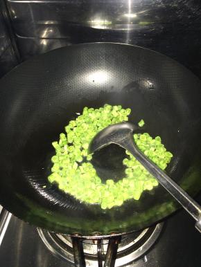 锅内放入适量油，加入葱花等调料，随后把豆丁放入锅中炒熟。