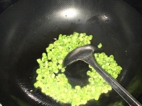 锅内放入适量油，加入葱花等调料，随后把豆丁放入锅中炒熟。